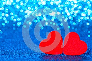 Red little decorative hearts against blue sparkle glitter background with amazing bokeh lights. Love or romantic Valentine day