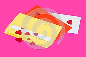 Red little hearts coming out from envelope isolated on pink background with copy space, loveletter concept