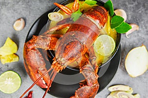 Red lobster spicy soup bowl - Cooked seafood with lobster dinner table and spices ingredients on black plate thai food ,Tom Yum