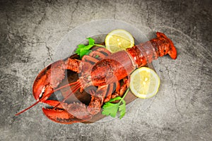 Red lobster with vegetable and lemon on wooden cutting board and black plate background , top view - Lobster dinner