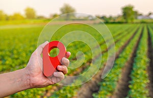 Red location pin on farm field. Buying and selling land. Land market. Plot Boundary Demarcation Service. Legal regulation photo