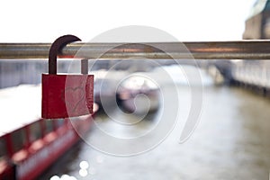 Red lock with a heart on a fence grate with an empty space as a symbol of love