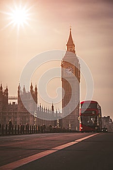 Red London Bus on the Westminster Bridge and Big Ben Tower in the background