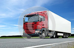 Red lorry with white trailer over blue sky photo