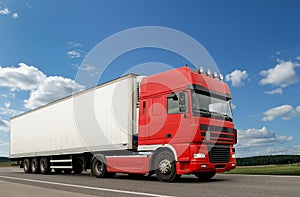 Red lorry with white trailer over blue sky