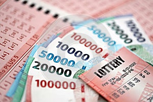 Red lottery ticket lies on pink gambling sheets with indonesian rupiah money bills