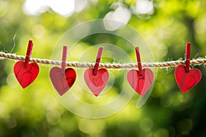 red love hearts pegged onto a clothes line outdoors