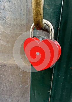Red love padlock on a metal door