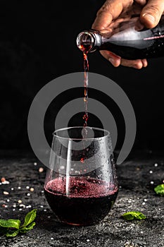 Red low alcohol drink, chilled colorful beverages on rustic black background. summer party. Alcoholic drink concept. Freeze motion