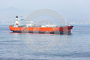 Red LPG tanker at anchor while calm weather.