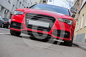 red luxury car parked on city