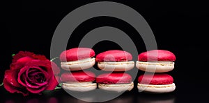 Red macaroon on black background with red roses