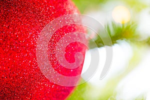 Red macro Christmas bauble with shiny lights reflection hanged o