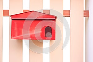 Red mail box hanging on fence