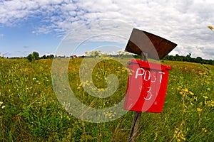 Red mail post box in a field