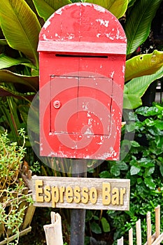 Red mailbox with brown wood with espresso plate background