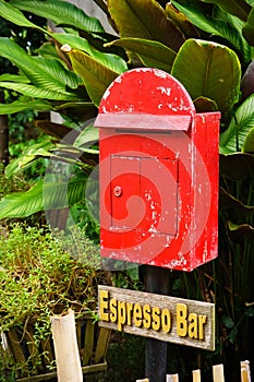 Red mailbox with brown wood with espresso plate background