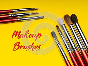 Red makeup brushes on yellow background