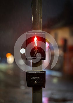 Red man stop sign illuminated at night on traffic light zebra crossing