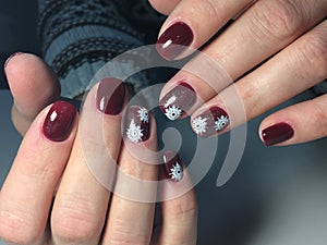 red manicure with delicate white snowflakes