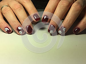 red manicure with delicate white snowflakes