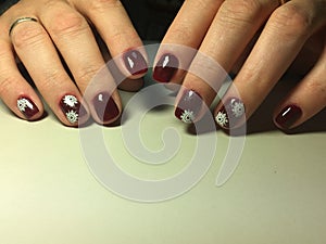 red manicure with delicate white snowflakes