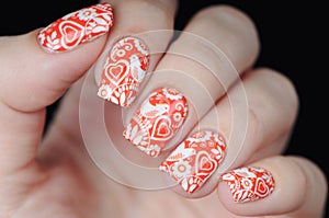 Red manicure on St. Valentine s Day with white heart pattern