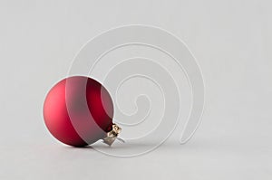 Red matte Christmas ball on a seamless grey background