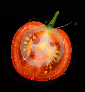 Red mature tomato isolated on a black background