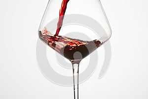 Red mature wine is poured into transparent glass.
