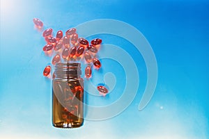 Red medical pills and tablets spilling out of a drug bottle. Pharmaceutical medical treatment healthcare concept.