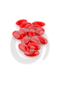Red medicine pills on white