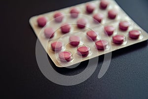Red medicines: tablets, pills in blister pack, medications drugs, macro, selective focus