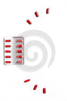Red medicines on a white background - tablets in capsules, pills in packages