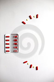 Red medicines on a white background - tablets in capsules, pills in packages