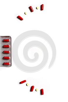 Red medicines on a white background - tablets in capsules, pills in packages