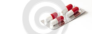 Red medicines on a white background - tablets in capsules, pills in packages