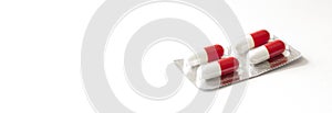 Red medicines on a white background - tablets in capsules, pills in packages. Pharmaceuticals, bright vitamins and medicines for