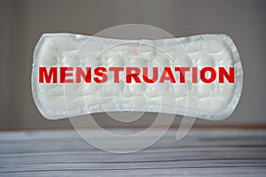 Red menstruation inscription on panty liner or sanitary napkin. Puberty of girls and the period of women