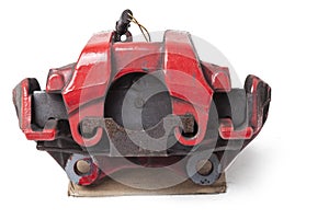 Red metal brake caliper on a white background in a photo studio for replacement during the repair of the chassis or for a catalog