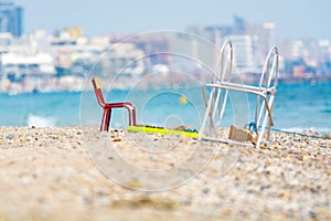 Red metal chair on sandy beach, Montpellier France