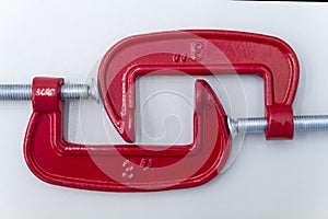 red metal clamp, press for locksmith work.red G-clamps