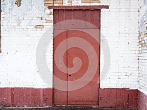 Red metal door in white colored brick wall