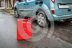 Red metal fuel tank for transporting and storing petrol. Filling the car from the canister