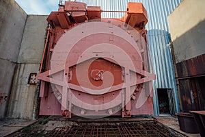 Red metal hermetic gateway door of airlock of nuclear reactor of abandoned unfinished power unit of nuclear power plant