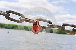 Red metal lock heart-shaped lock on a metal chain