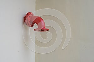 Red metal pipe on the white wall