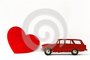 Red metal retro toy car and heart on white background. Valentine's day concept