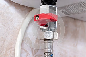 Red metal sanitary valve that provides water supply from a water heater, boiler