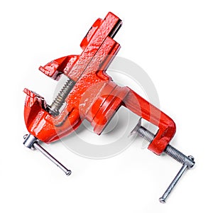 Red metal table vise clamp with opened jaws isolated on white ba